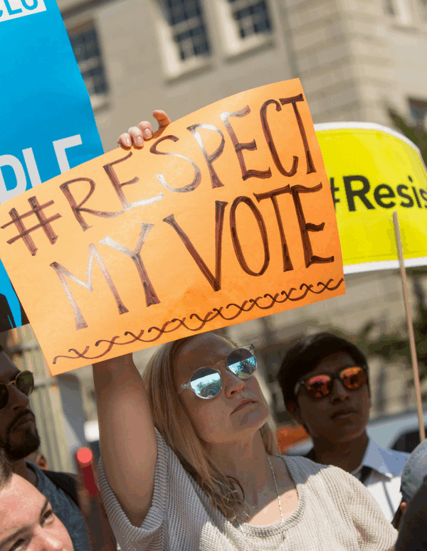 protesters holding signs that say Respect My Vote