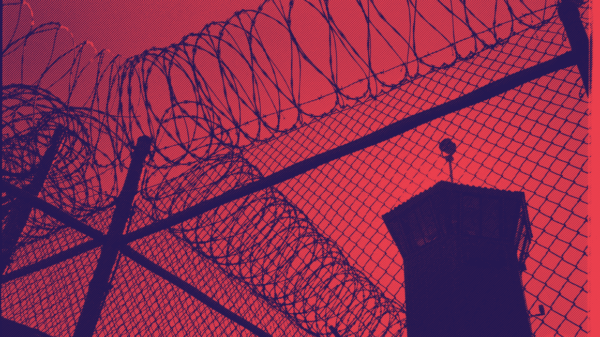 a picture of barbed wire and a prison watch tower