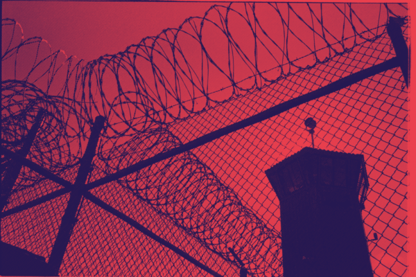 a picture of barbed wire and a prison watch tower