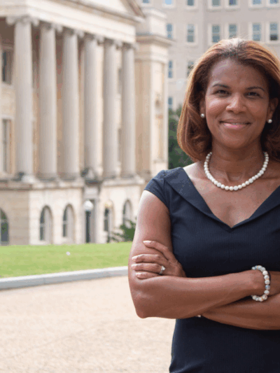 Kemba Smith standing in front of a court house with her arms folded in front of her chest