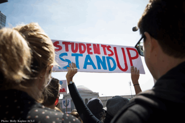 A student held a sign saying "Students Stand Up" in red and blue at the March for Our Lives in 2018