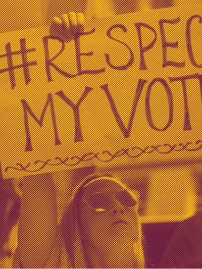 A white woman holding a sign that says "hashtag Respect My Vote"