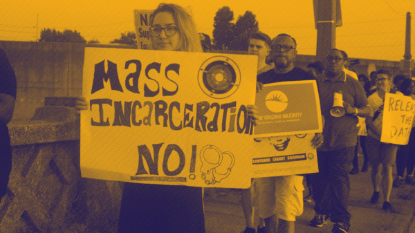 A protester holding sign that says "Mass incarceration No!"