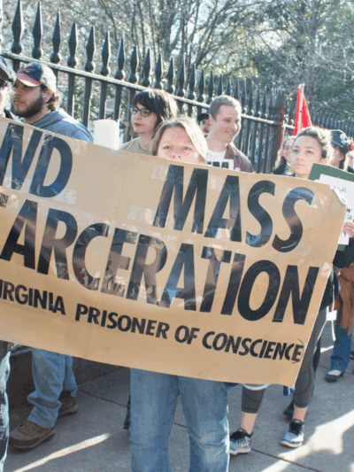 Protesters holding sign that says "End Mass Incarceration - VAPOC Virginia Prisoner of Conscience"
