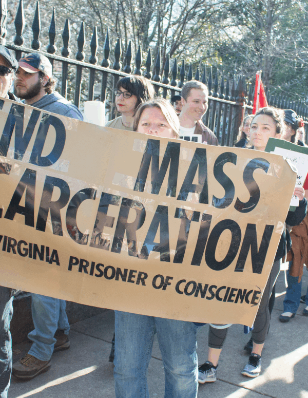 Protesters holding sign that says "End Mass Incarceration - VAPOC Virginia Prisoner of Conscience"