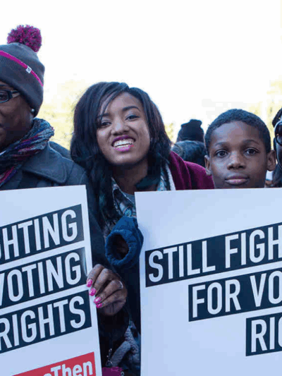 a group of black voters held signs that say "still fighting for voting rights"