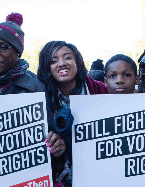 a group of black voters held signs that say "still fighting for voting rights"