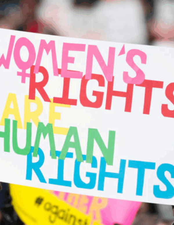 picture from the 2018 Women's March in Richmond, of a dark-skinned woman holding a sign that said "women's rights are human rights" and another white woman holding a sign that said "Power to the Polls"