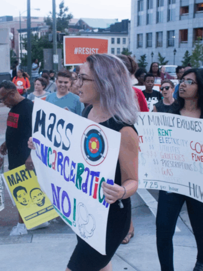 A woman protester holding a sign that says "Mass Incarceration NO!"