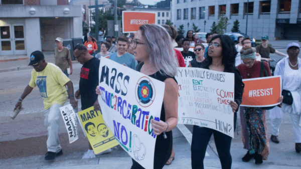 A woman protester holding a sign that says "Mass Incarceration NO!"
