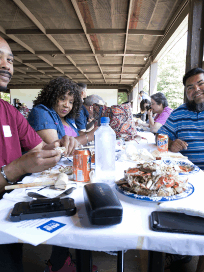 photo from our 2019 Crabfest of attendees eating crab and talking