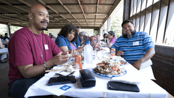 photo from our 2019 Crabfest of attendees eating crab and talking