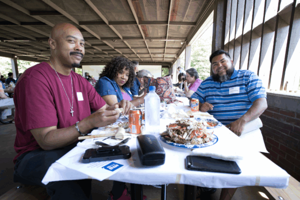 photo from our 2019 Crabfest of attendees eating crab and talking
