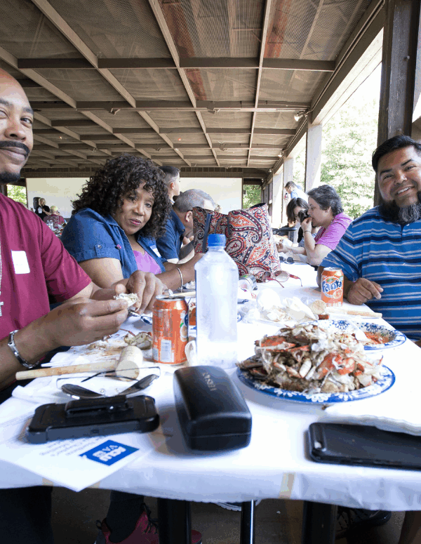photo from our 2019 Crabfest of attendees eating crab and talking