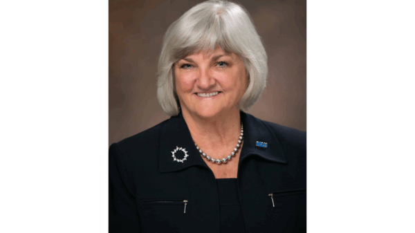 portrait of our executive director Claire Gastanaga, with shoulder length silver hair, round face, blue eyes, and wearing all black.