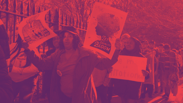 Protesters holding a sign that says "Let Equality Bloom"