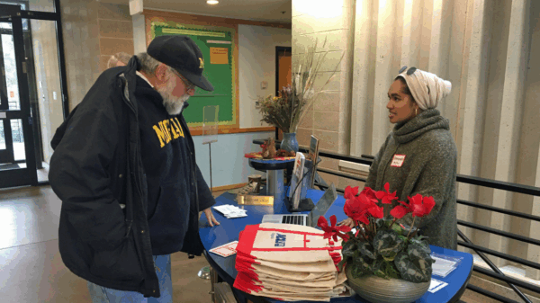 Our intern Ameenah in her hijab at the reception table greeting guests at our 2020 Legislative forum
