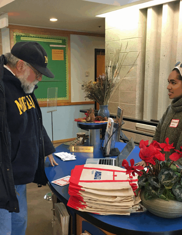 Our intern Ameenah in her hijab at the reception table greeting guests at our 2020 Legislative forum