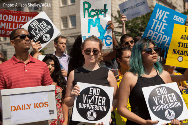 protesters holding signs that say "respect my vote" and "end voter suppression"
