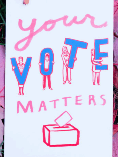 A protest sign that says "Your Vote Matters" against a background of red maple leaves
