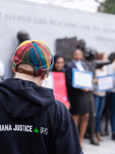 a protester wearing a hoodie with Marijuana Justice logo on