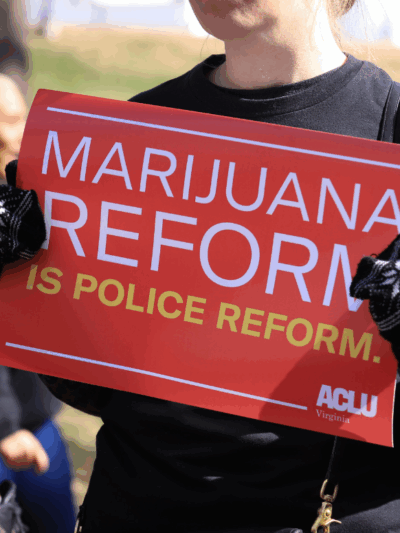 a red protest sign that says "marijuana reform is police reform"