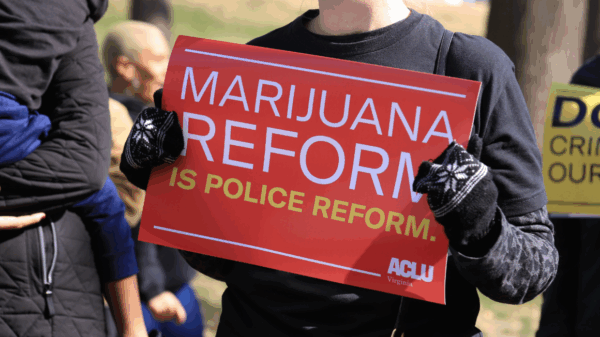 a red protest sign that says "marijuana reform is police reform"