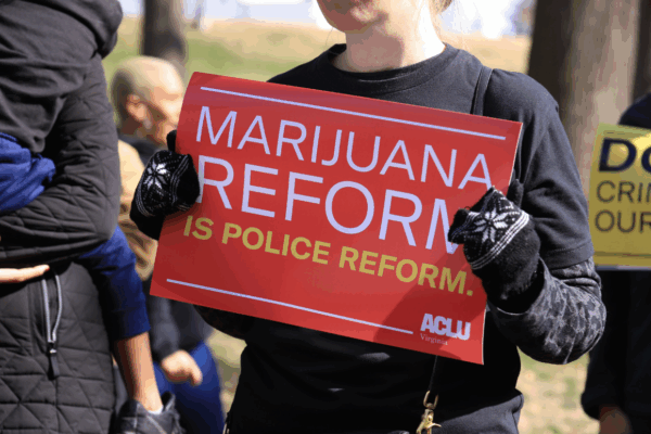 a red protest sign that says "marijuana reform is police reform"
