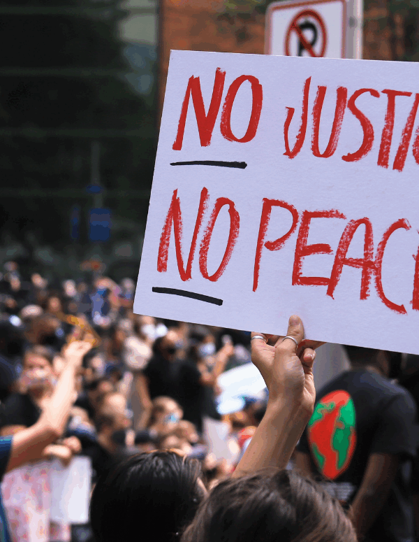 a white protest sign with the text in red "No Justice No Peace"