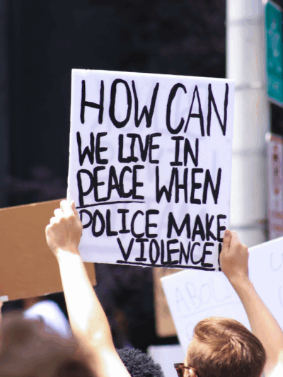 a protest sign with the text "how can we live in peace when police makes violence"