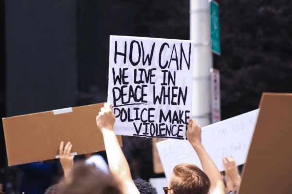 a protest sign with the text "how can we live in peace when police makes violence"