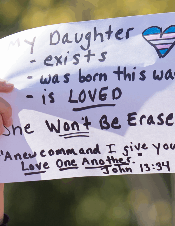 a protest sign with the message: My daughter exists, was born this way, is LOVED. She won't be erased.