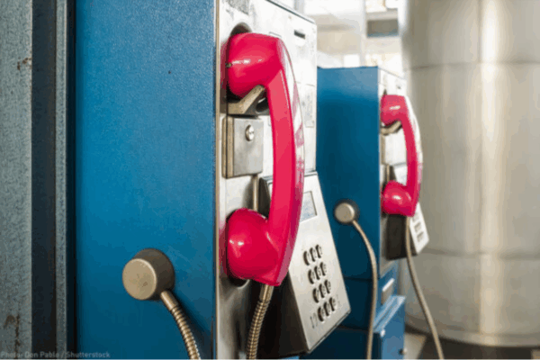 pay phone booths in prison with red phone over blue booth.