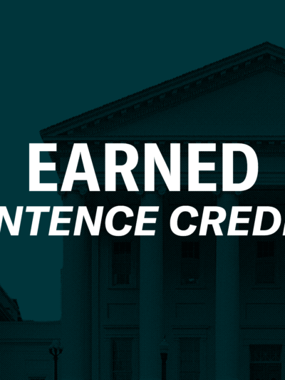 Over a a dark green background of the Virginia state capitol is a person embracing a recently returned Virginian in a hug. To the right of the graphics is a black gavel. In the middle of the graphic is text, "Earned sentence credits."