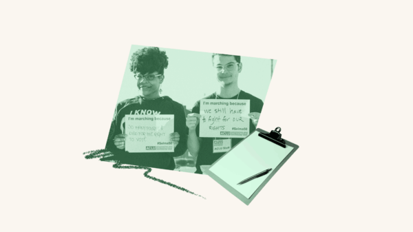 Two people holding up signs with a clipboard.