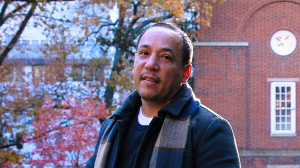Angel DeJesus smiles at the camera with the Bell Tower in the background