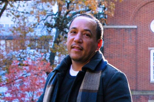 Angel DeJesus smiles at the camera with the Bell Tower in the background