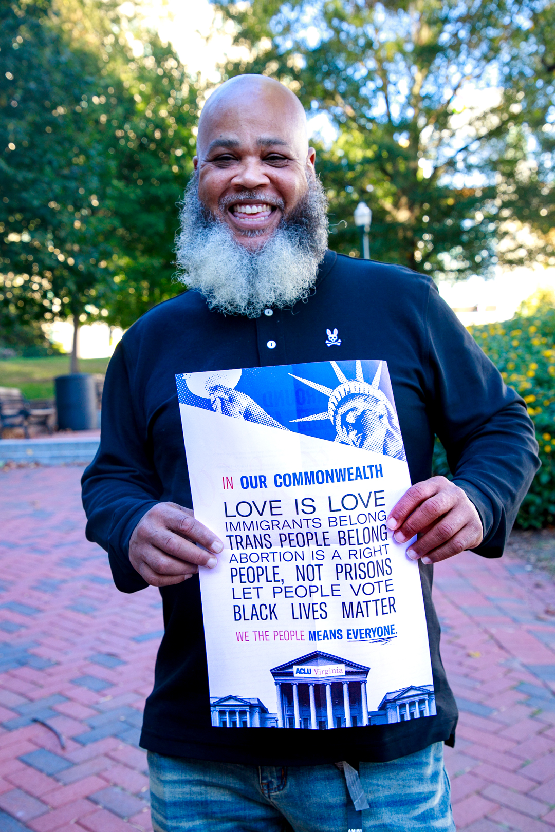 Tati smiles joyfully holding a poster