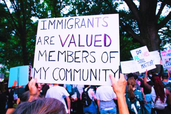protest sign with the message "immigrants are valued members of my community."