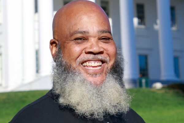 Tati smiles brightly at the camera while standing in front of Virginia Capitol