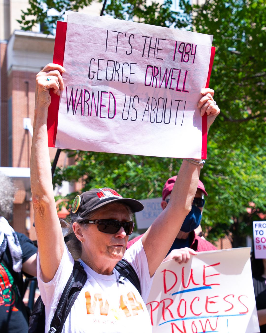 a protester held up a sign with the message "It's the 1984 George Orwell warned us about!"