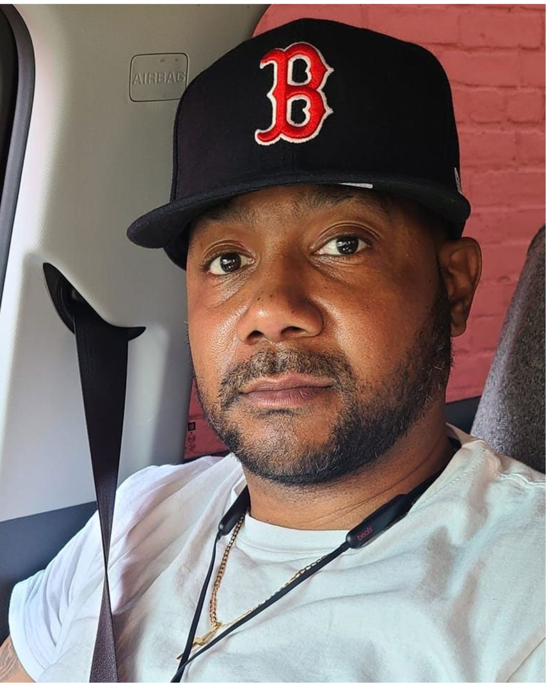 Sincere, a Black man in his 40s, wearing a white tshirt and Boston Red Sox cap