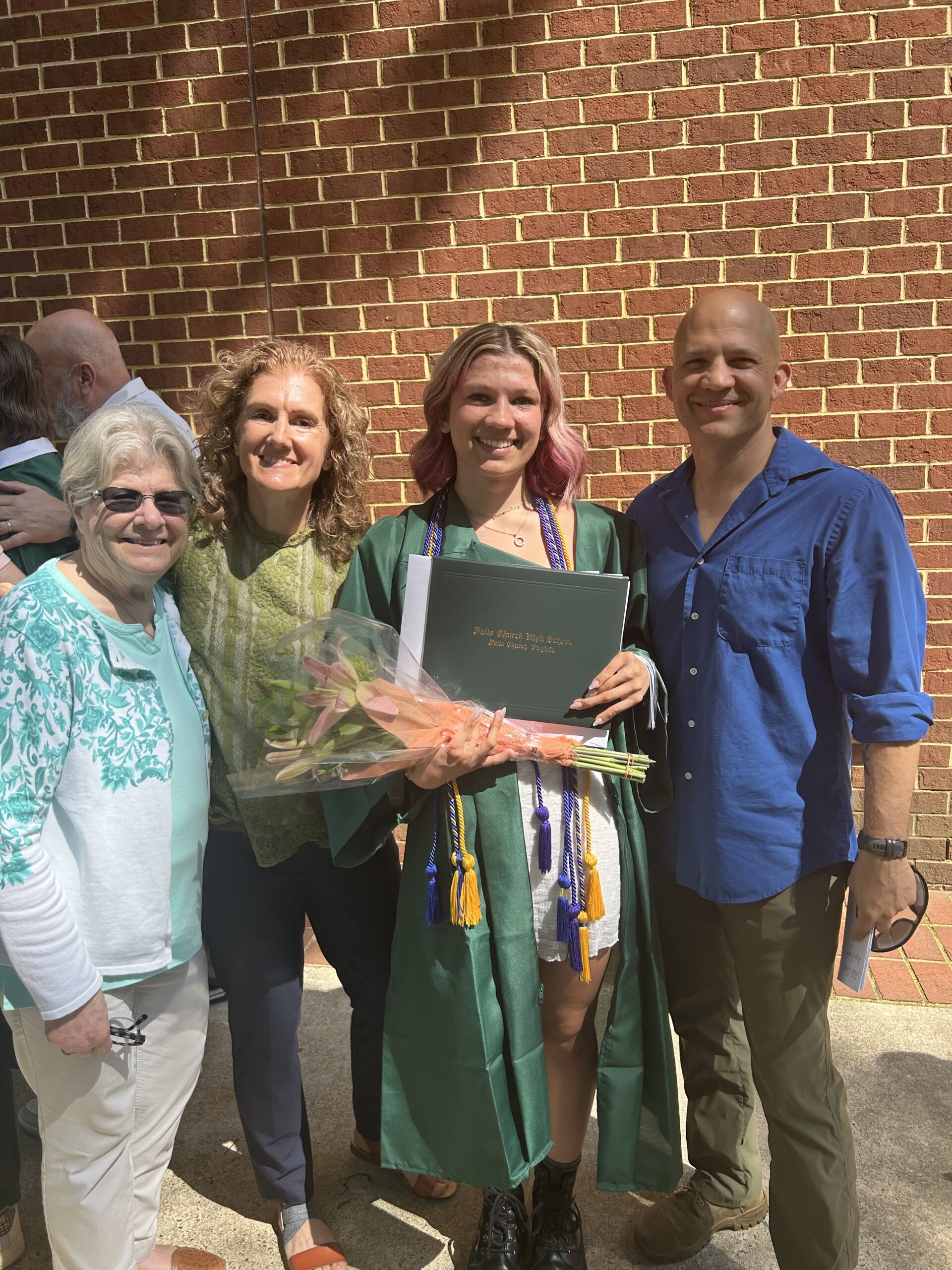 Eliza with her mom and dad and nana at her graduation in 2025