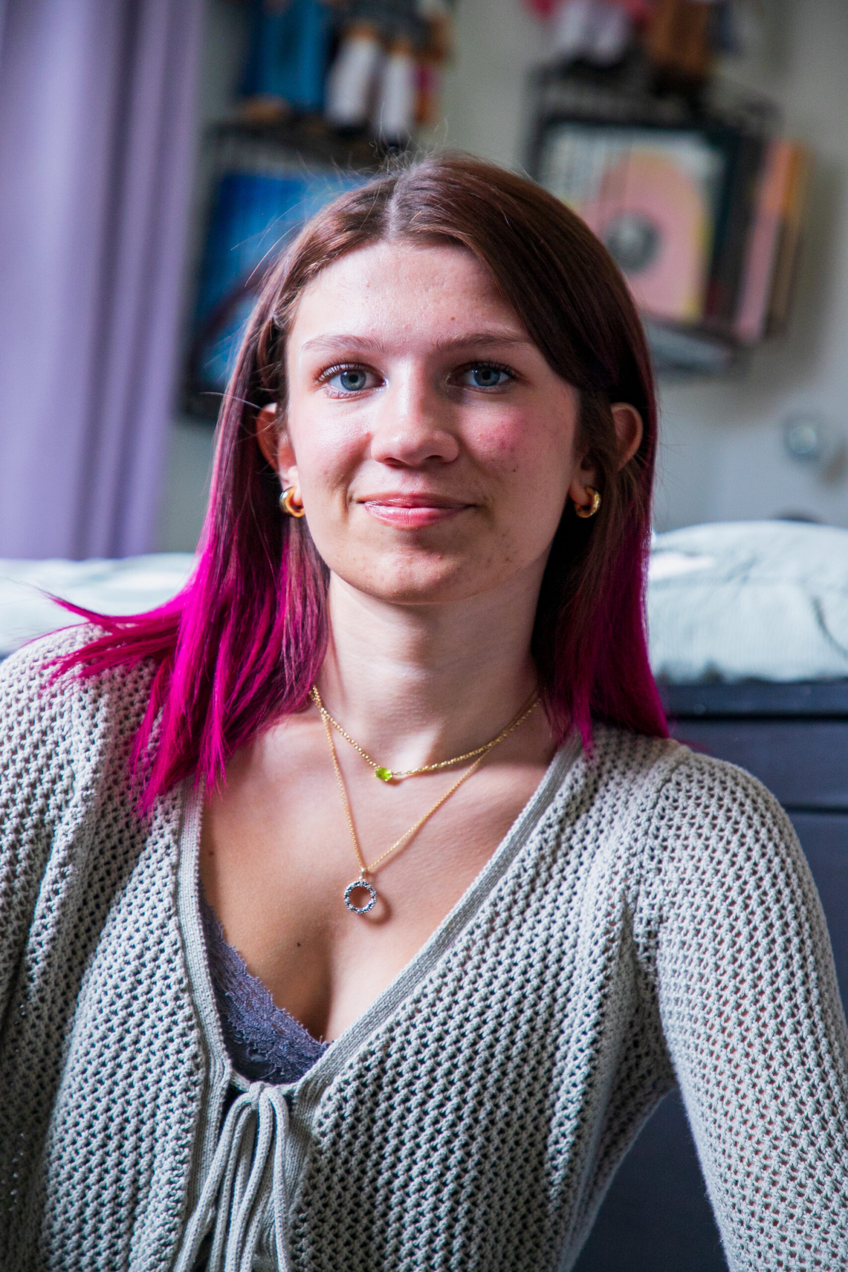 Eliza with her signature pink hair smiling confidently at the camera