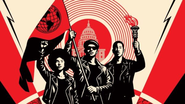 Three people wearing all black stand tall with their fists in the air. The person in the middle is holding a red flag with a black outline of the world.