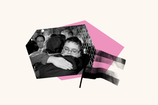 A person is seen hugging another person while in a crowd of people. A trans flag is layered over the image of the people embracing one another.