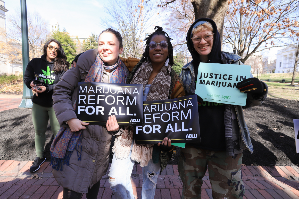 MJ Reform for All.png Three advocates holding signs that say "marijuana reform for all" and "justice in marijuana"