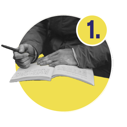 A person writing in a notebook over a yellow circle.