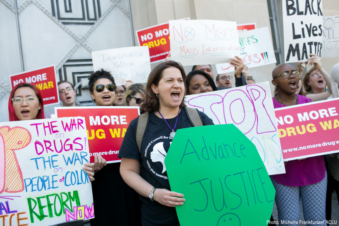 protesters holding signs with pro-criminal justice reform messages