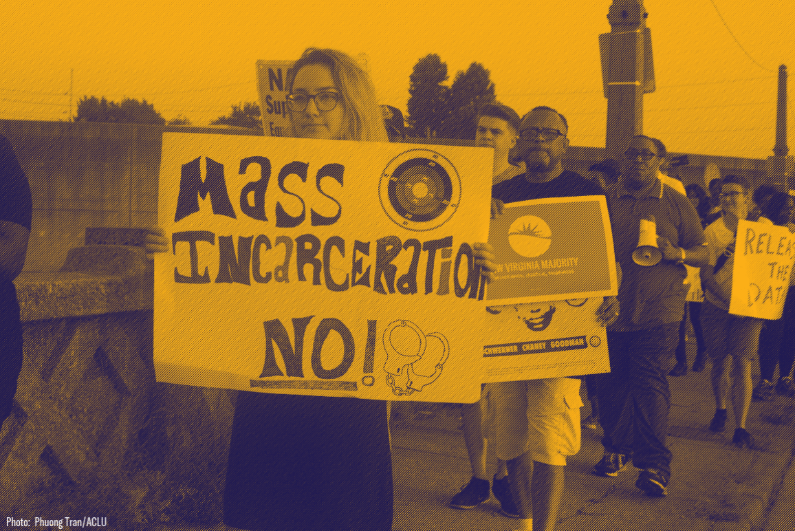 A protester holding sign that says "Mass incarceration No!"